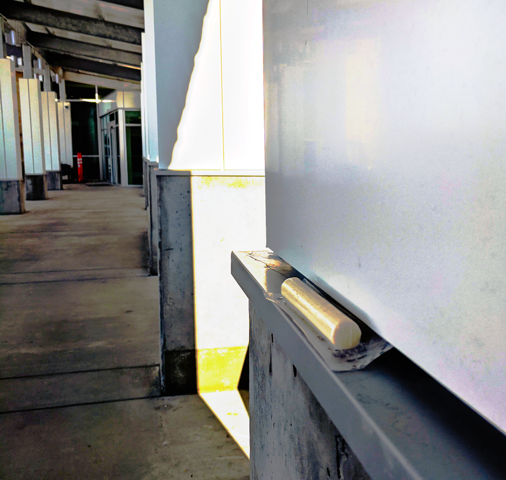 A string cheese in plastic, sitting on a pillar in a breezeway