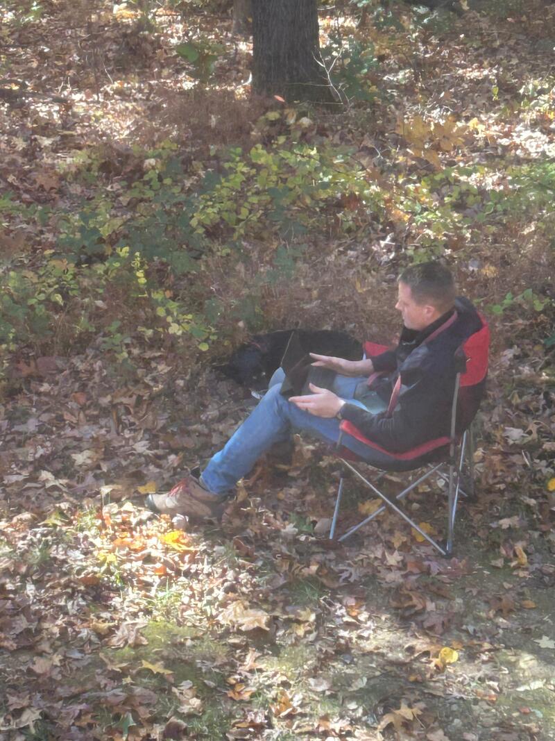 Clapton laying in the grass, Karl working on a tablet.